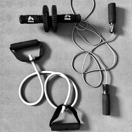 Travel-friendly gym equipment for efficient workouts: resistance band handles, jump rope, and ab roller.
