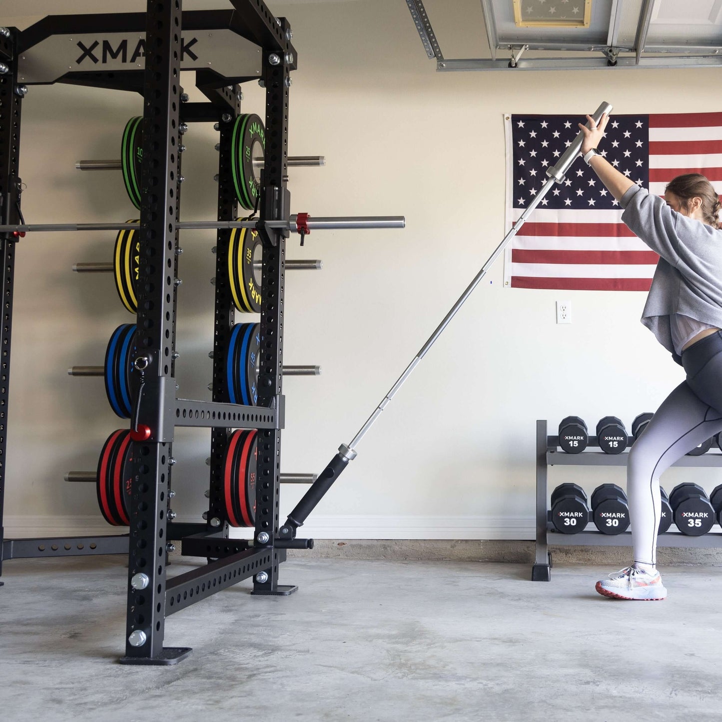 Person using the Viper Attachment Package with a landmine in a garage gym setting, showcasing workout versatility.