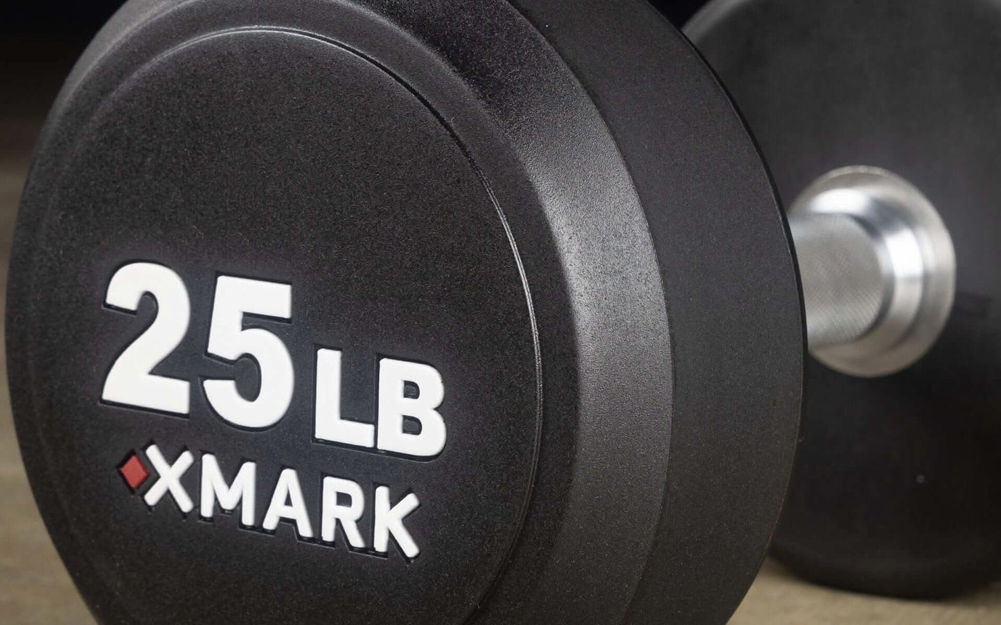 Close-up of a 25 lb XMARK urethane dumbbell, ideal for commercial gyms and serious strength training.