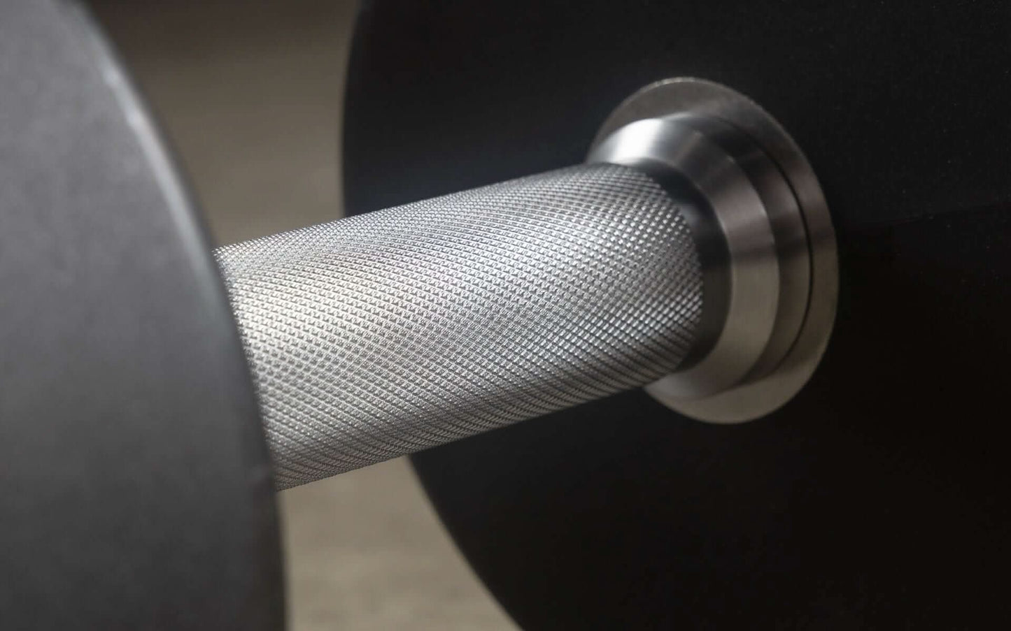 Close-up of XMARK round urethane dumbbell showcasing textured grip and sturdy construction for strength training.