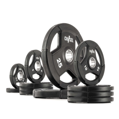 Chisel Olympic weight plates of varying sizes, featuring recessed tri-grip handles and a sleek rubber design.