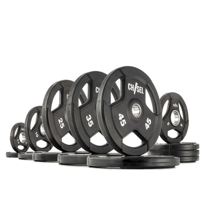 Chisel Olympic weight plates in various sizes, featuring recessed tri-grip handles and rubber encasing.