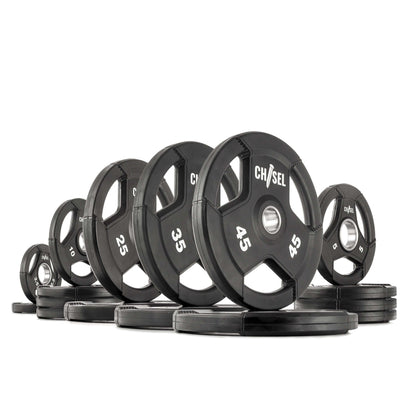 Chisel Olympic weight plates in various sizes, showcasing a sleek black design with recessed tri-grip handles.