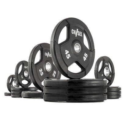 Chisel Olympic weight plates in various sizes, featuring recessed tri-grip handles, rubber encasing, and stainless-steel flanges.