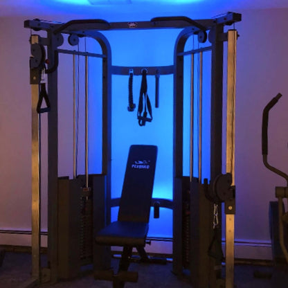 Functional trainer cable machine with dual 200 lb weight stacks and adjustable seat in a softly lit gym setting.