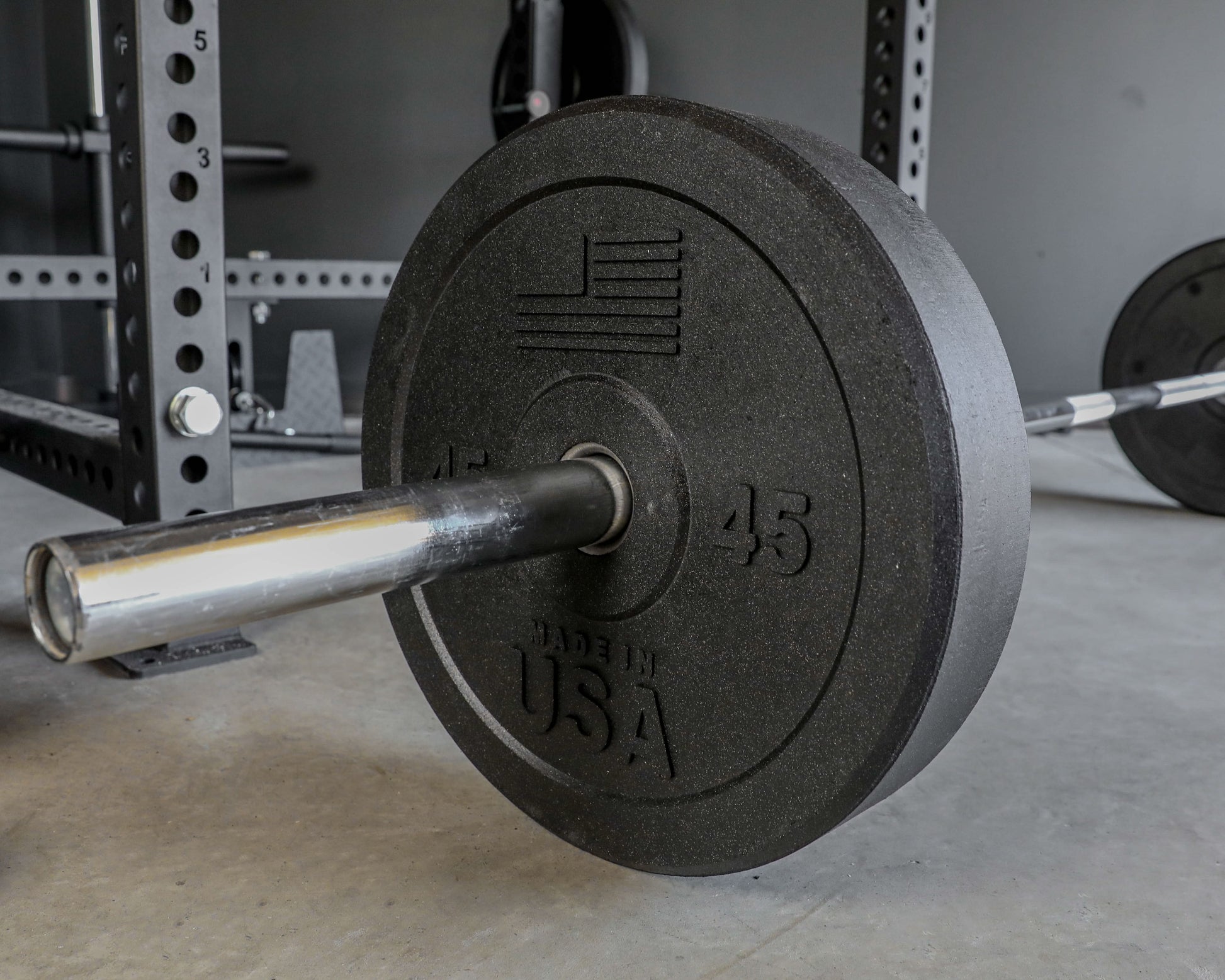 USA Bumper Plates - close up view with plate on a barbell on the ground (45 lbs)