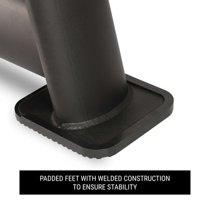 Close-up of padded feet with welded construction for stability on a commercial dumbbell rack.