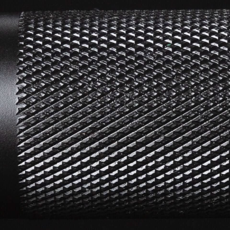 Close-up of textured black grip featuring volcano knurling for secure handling on the Catahoula IWF Men's Training Bar.