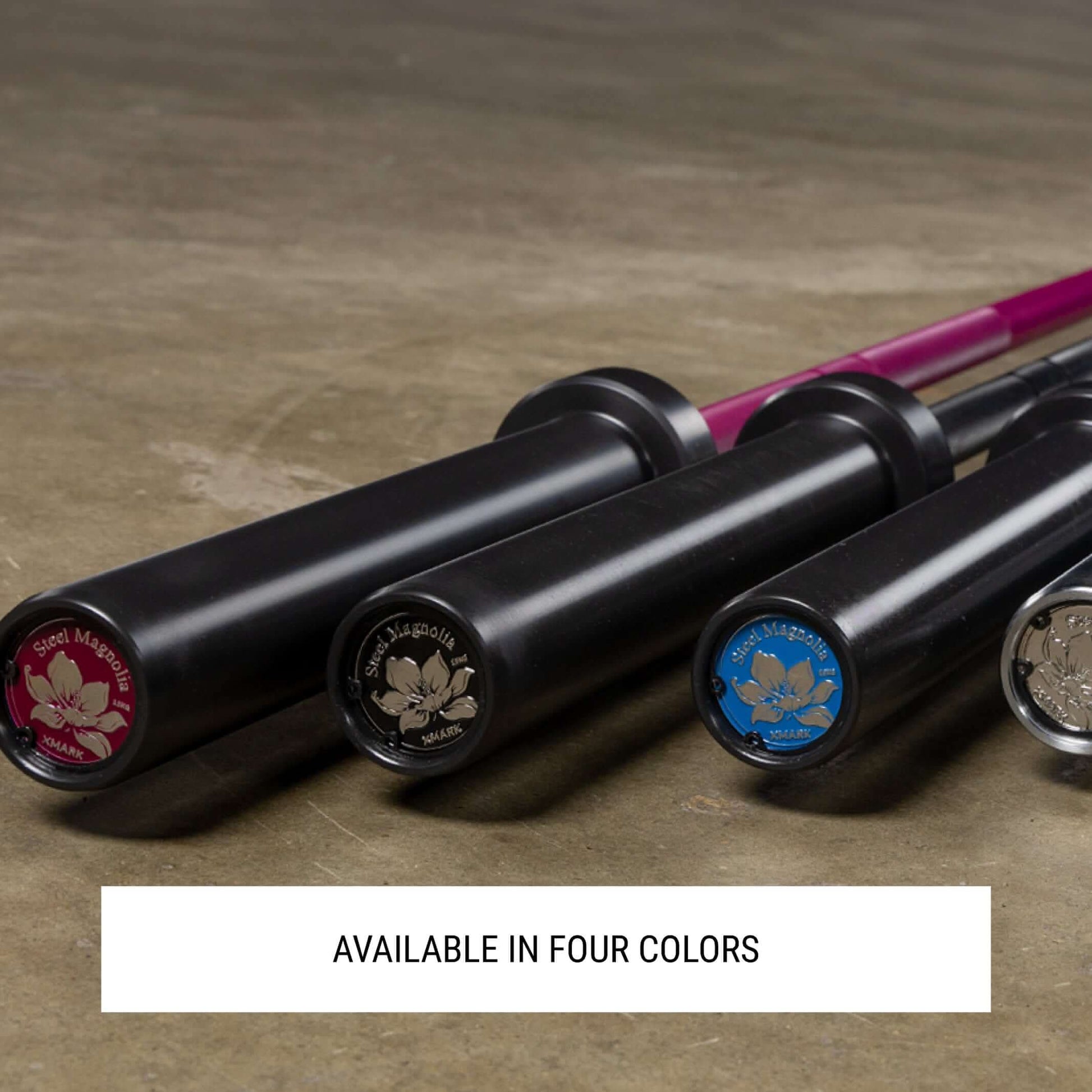 Four Steel Magnolia IWF training bars in different colors, featuring durable black shafts and colorful end caps.