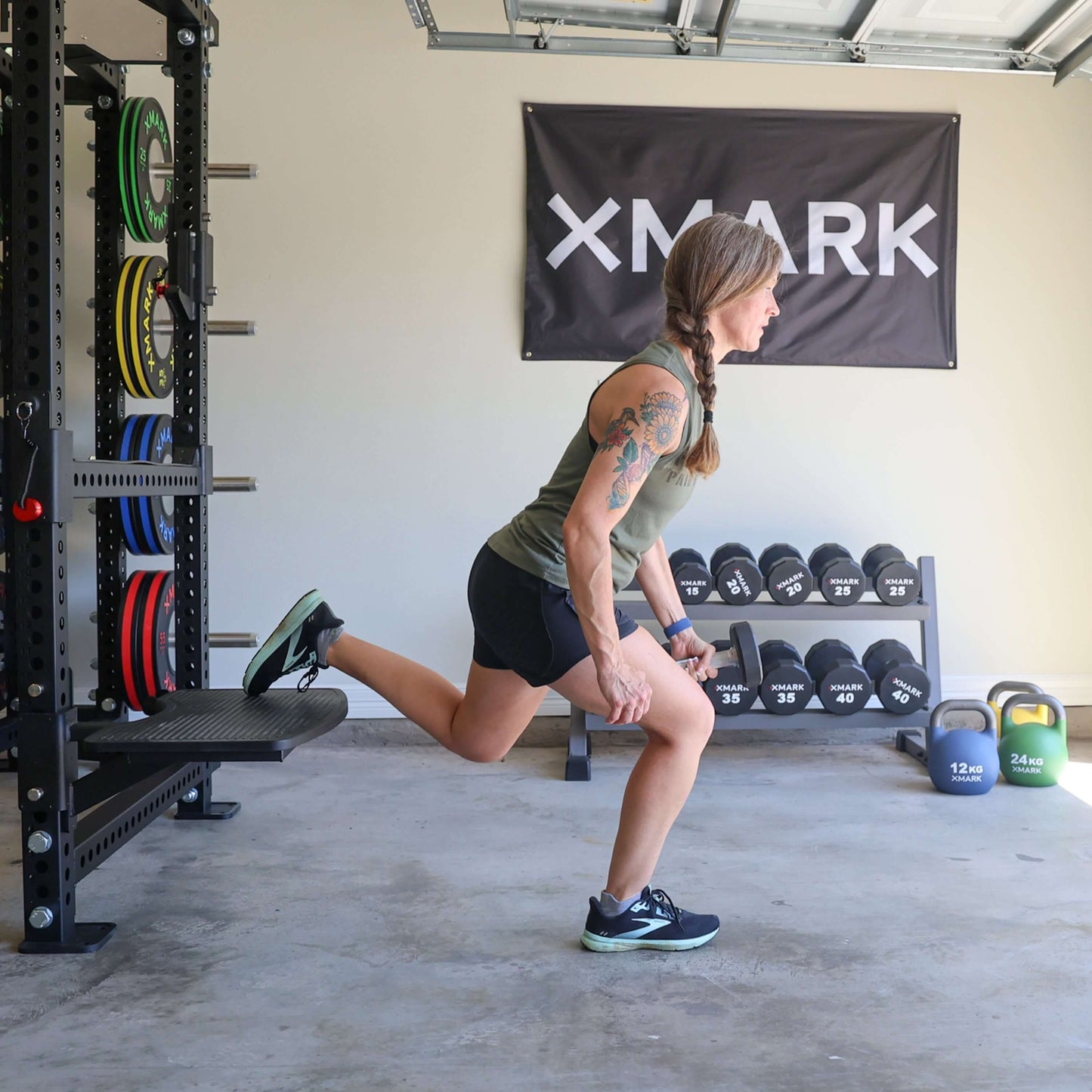 Woman performing Bulgarian split squat using Viper Multi-Purpose Step Attachment in a gym setting with weights.